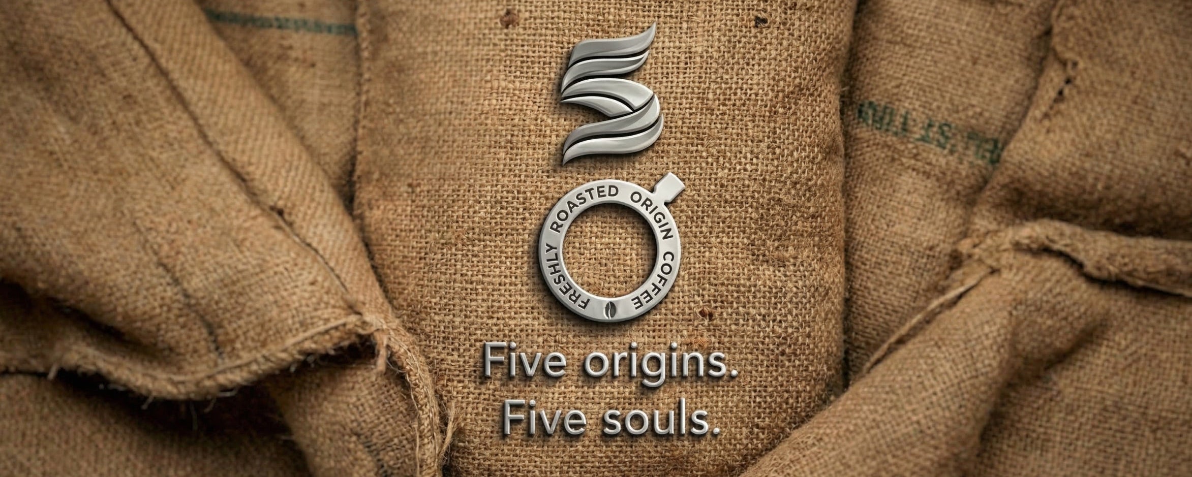 Close-up of a brown fabric surface with a logo and text 'Five origins, Five souls' displayed.