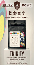 A coffee bag product display on a pedestal with branding for FiveO and Roasted in  Romania. The main subject is a black stand-up pouch labeled Trinity, with text indicating Omnilight Roast, Brazil/Honduras/Ethiopia origin, and 100% Arabica coffee beans.