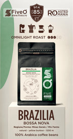 A bag of Five O' Coffee Brazilia Bossa Nova coffee beans displayed on a white pedestal. The packaging features a black resealable pouch with a white and green label, set against a white background with green and brown graphic accents and text detailing the roast and origin.